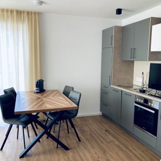 Küchenzeile mit modernen Geräten und Esstisch