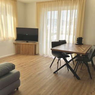Wohnzimmer mit Flat-TV und Balkon