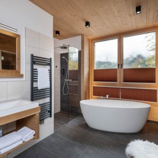Großzügiges Badezimmer mit Badewanne und Bergpanorama