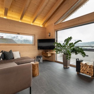 Geräumiges Wohnzimmer mit Flat-TV und Panoramafenster